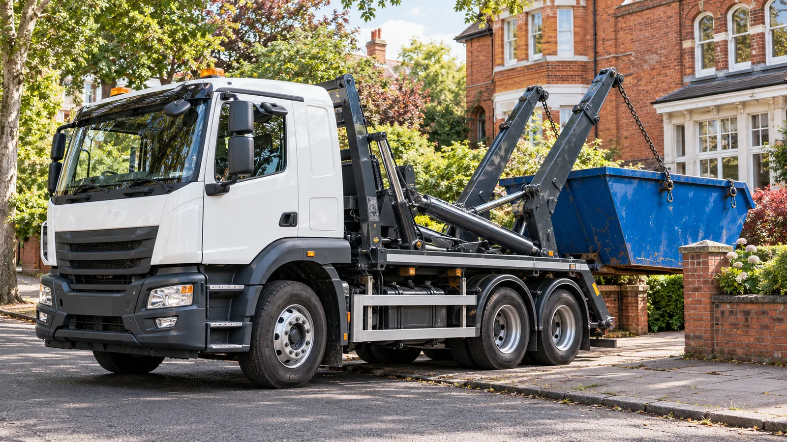 UK skip lorry with hydraulic lifting equipment on a leafy residential street