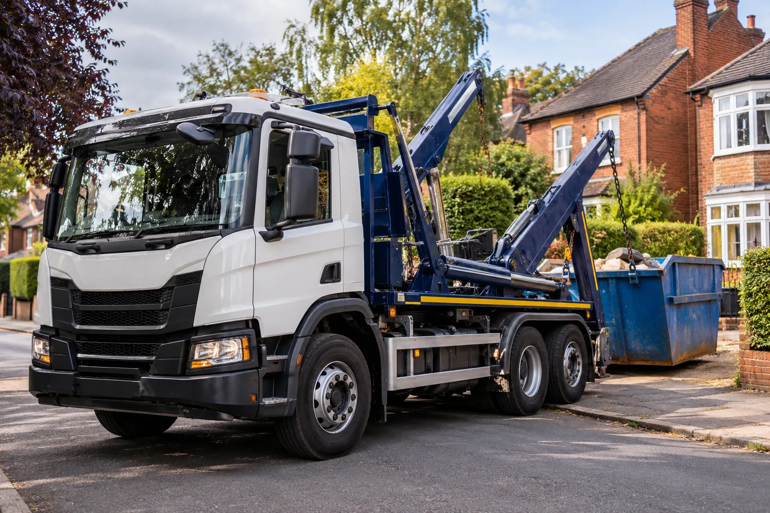 Skip delivery lorry with hydraulic equipment beside red-brick houses